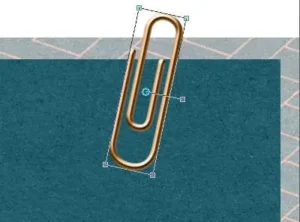 Paperclip rotated and positioned over layered papers using the Pick tool in PaintShop Pro
